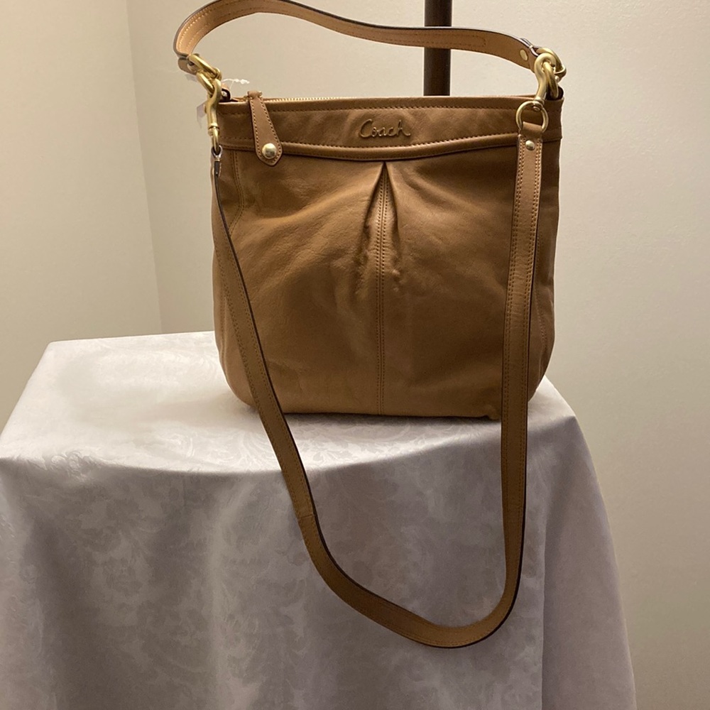 This is a coach leather bag with a shoulder strap and a carry handle